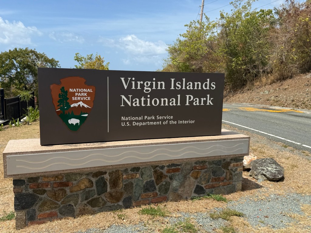 Sign marking the entrance to Virgin Islands National Park, featuring the National Park Service logo and guidelines.